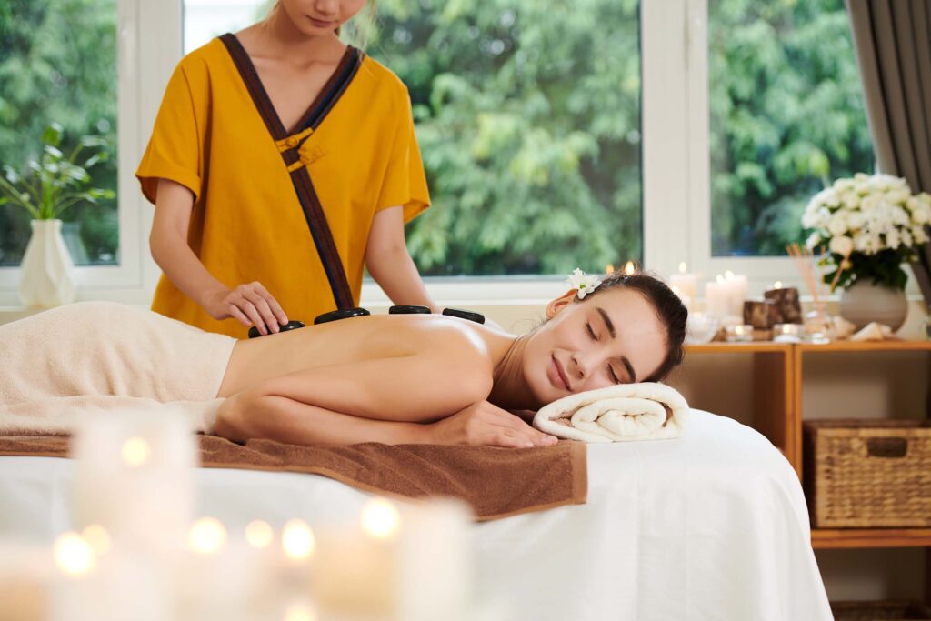 Woman enjoying a relaxing hot stone massage at a wellness spa.
